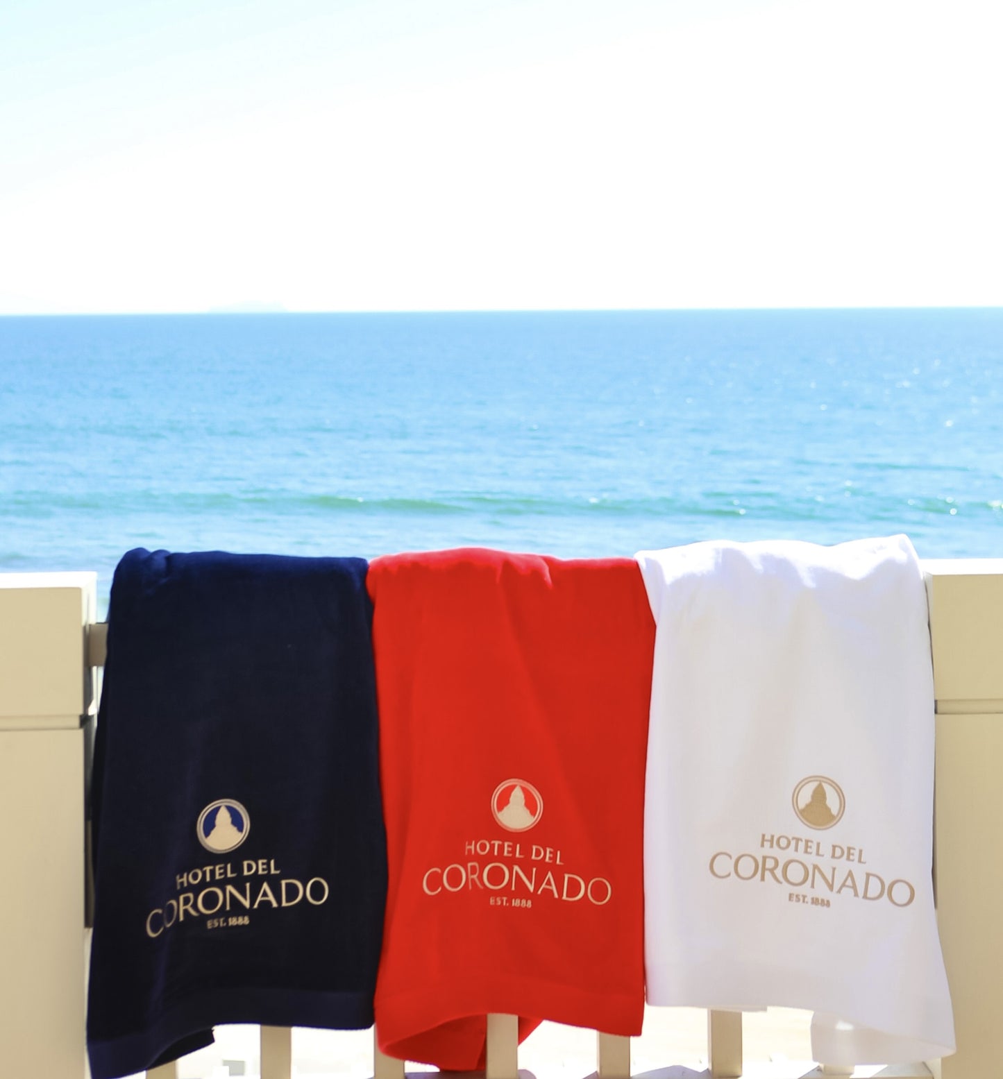 Three logo Hotel del Coronado towels in navy, red and white